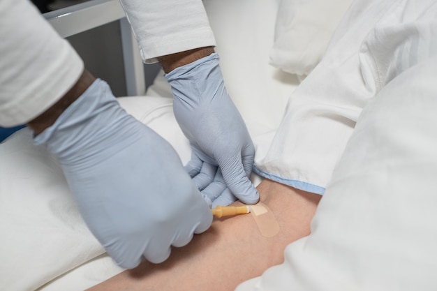 Premium Photo | Close-up of doctor in protective gloves putting ...