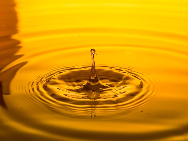 Premium Photo | Close up of a drop oil on a yellow background