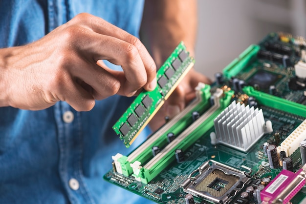 Close-up of engineer putting the ram memory module in computer motherboard Photo | Free Download