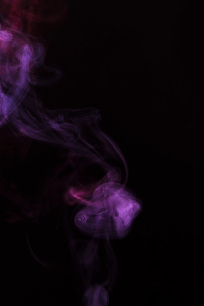 Close-up of faded purple smoke on black background | Free Photo