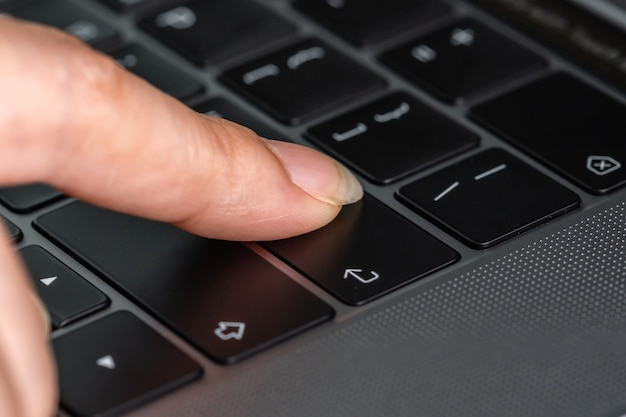 Premium Photo | Close-up female hand pressing enter button on a laptop ...