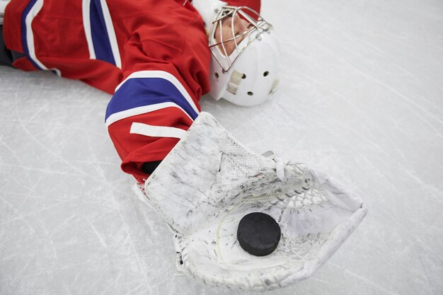 Premium Photo Close Up Of Female Hockey Player Lying On Ice And Holding Pluck Exhausted After Practice