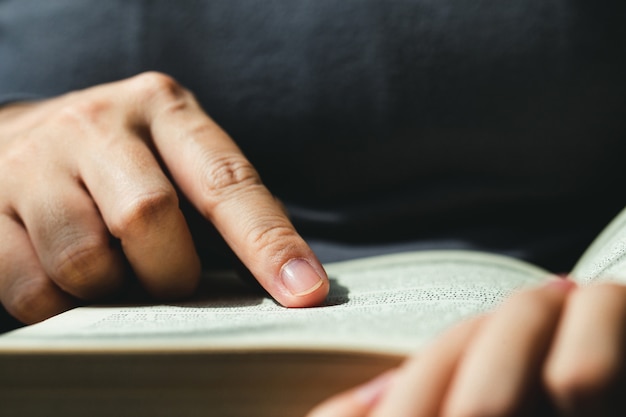 Premium Photo Close Up Of Finger Pointing Text In Bibleclose Up Of Man Reading Through The Bible 