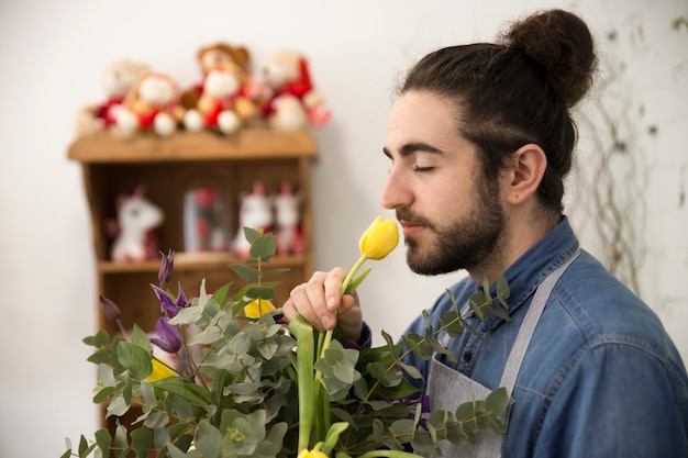 Close-up of florist man smelling the tulip flower in the ...