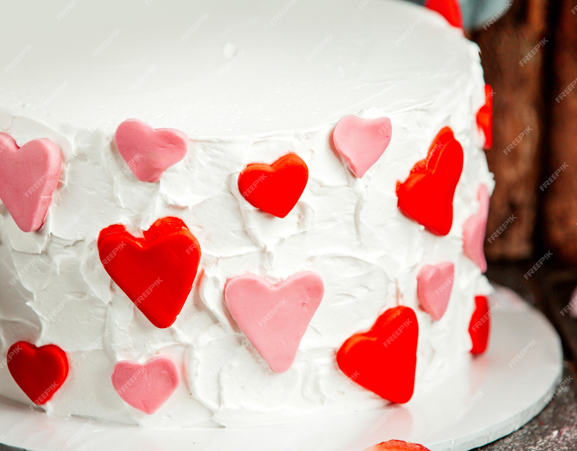 Free Photo | Close up of fondant hearts in red and pink on white creamy ...