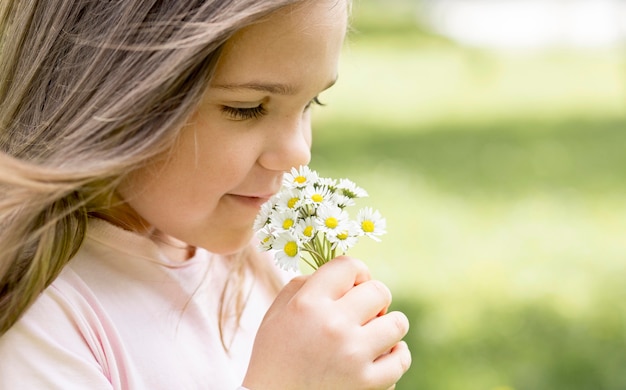 野の花の花束の臭いがするクローズアップの女の子 無料の写真