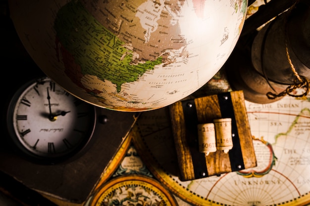 Close-up of globe, clock and historic map Free Photo