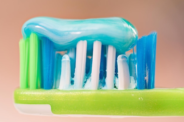 Premium Photo | Close up of a green toothbrush with toothpaste on its ...