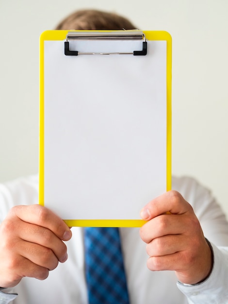 free-photo-close-up-hand-holding-a-clipboard-mock-up