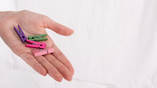 Free Photo | Close-up hand holding colourful clothes-pins