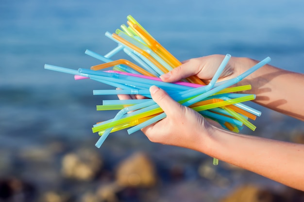 Premium Photo | Close up of hand holding plastic straws polluting beach ...