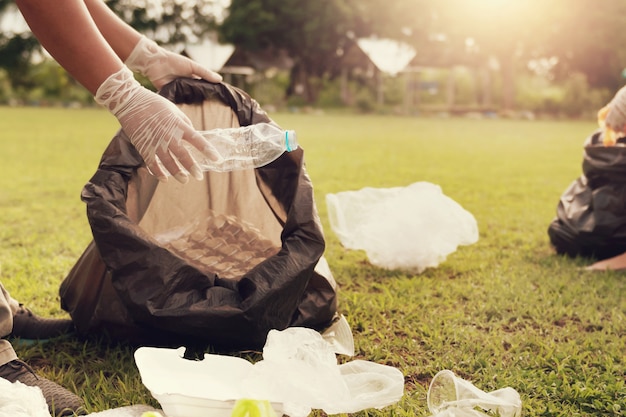 Close up hand picking up garbage plastic for cleaning at park Premium Photo