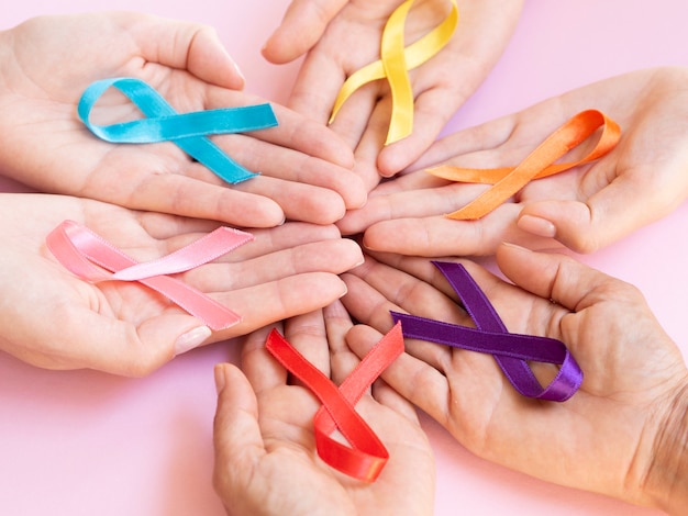 Close-up hands holding colorful awareness ribbons Free Photo