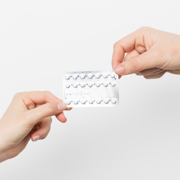 Close up hands holding contraceptive pills Free Photo