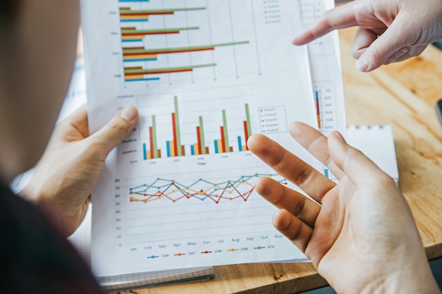 Close up hands.two young businessmen are analyzing investment charts. Premium Photo