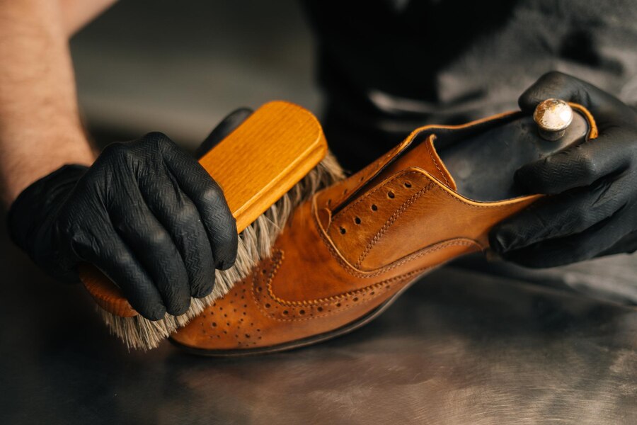Premium Photo | Close-up hands of unrecognizable shoemaker cleaning ...