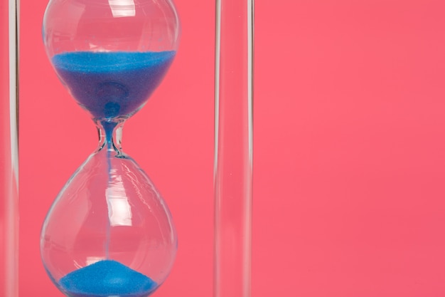 Premium Photo | Close up of hourglass on pink