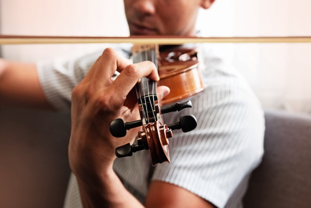 Close up human hand pressing string of violin, show how to play the instrument Premium Photo