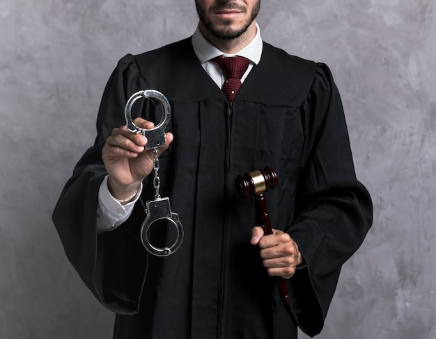 Close-up judge with handcuffs and gavel Free Photo