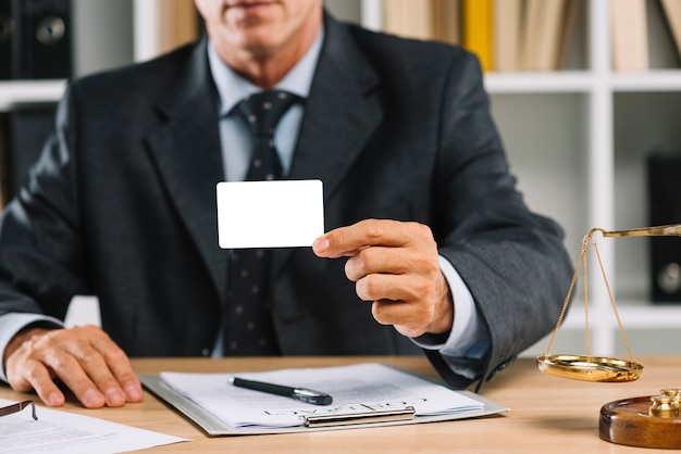 Close-up of lawyer showing white blank card with contract on table Free Photo