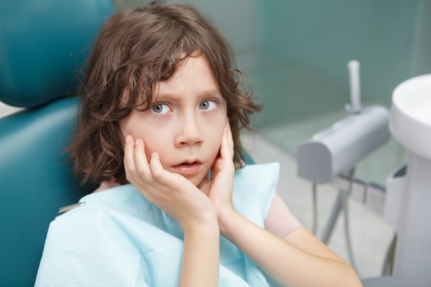 Premium Photo | Close up of a little boy looking terrified, sitting in ...