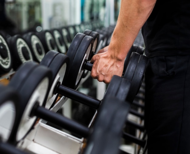 Premium Photo | Close-up male at gym choosing weights