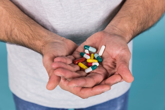 Close-up of a male hand holding capsule's in hand | Free Photo