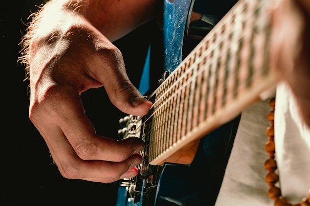 Premium Photo Close Up Of Male Hand Playing Electric Guitar In The Dark