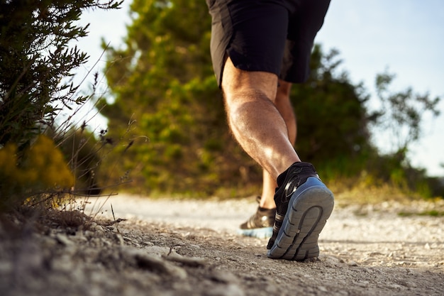 Premium Photo | Close up of male muscular legs running up the hill