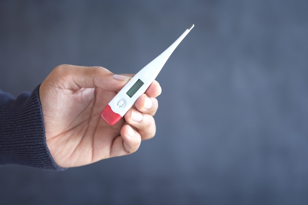 Premium Photo Close Up Of Man Hand Holding Digital Thermometer