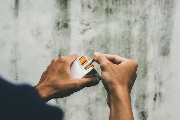 Premium Photo | Close up man hand holding peel it off cigarette pack ...