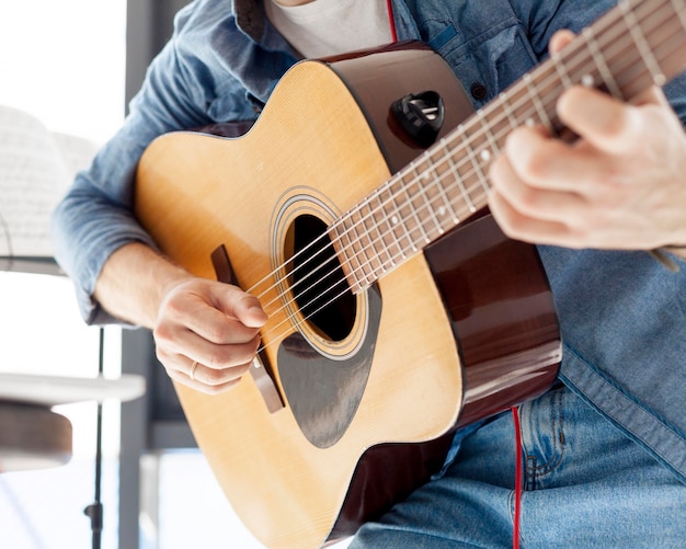 Free Photo Close Up Man Holding An Accoustic Guitar