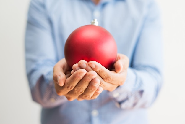 Free Photo | Close-up of man holding beautiful red christmas ball
