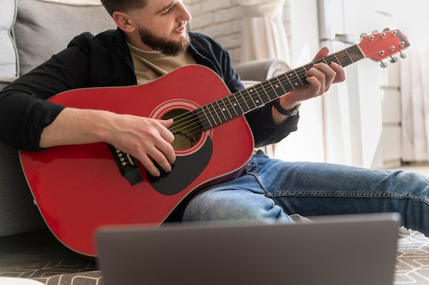 Free Photo Close Up Man Playing Guitar On Floor