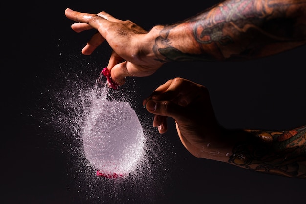 Close Up Man Popping A Water Balloon Free Photo