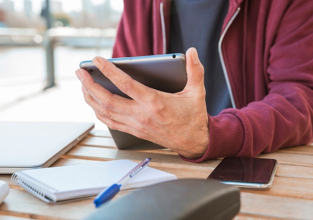 Close Up Of Man S Hand Holding Digital Tablet In Hand At Outdoors Caf