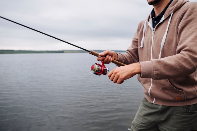 Free Photo Close Up Of Man S Hand Holding Fishing Rod Near The Lake