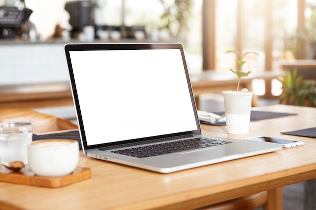 Close up minimalist shot of generic laptop computer and working accessories resting on wooden table Free Photo