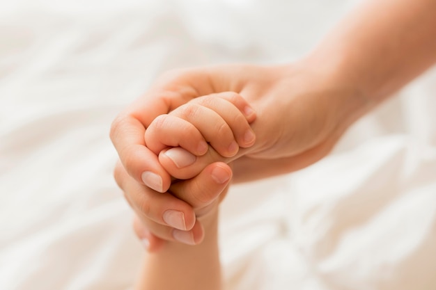 Download Close-up mom and baby holding hands | Free Photo