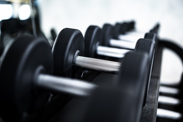 Premium Photo | Close up of new dumbbells on a rack in a gym