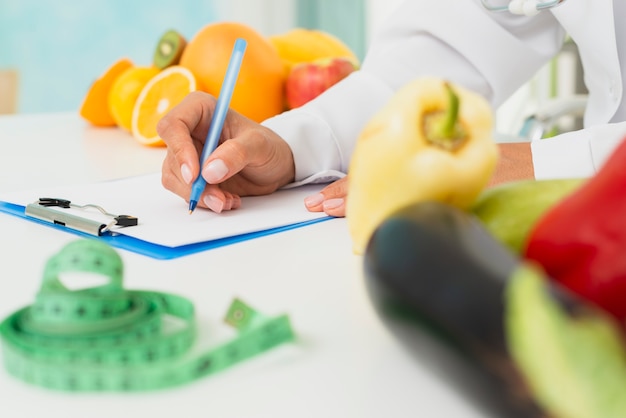 Close-up nutritionist writing prescription Free Photo