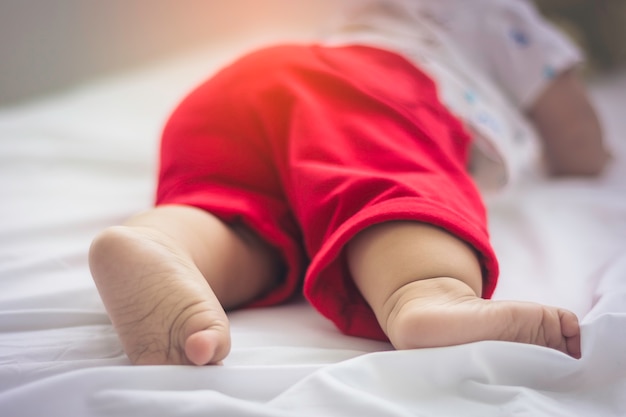 赤い綿のズボンを身に着けている赤ちゃんの足のクローズアップ プレミアム写真