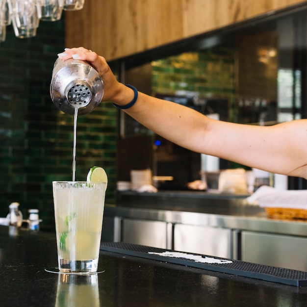 Close-up of a woman's hand making cocktail at bar counter Free Photo Close-up of a woman's hand making cocktail at bar counter Free Photo