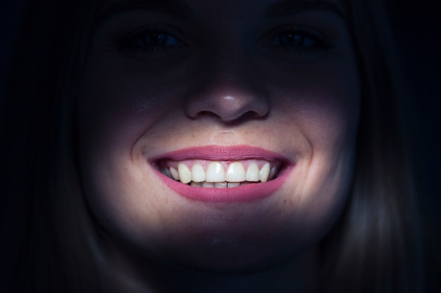 Close-up of a woman's illuminated teeth Free Photo