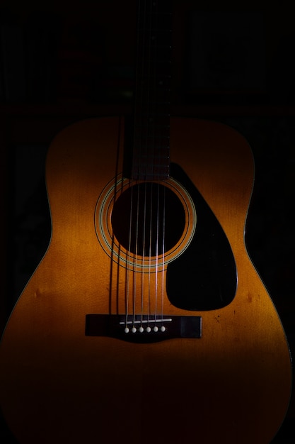 オンライン売り出し 光や影の間の黒い背景にアコースティックギターのクローズアップ 売上 格安 Piu Ac Ke