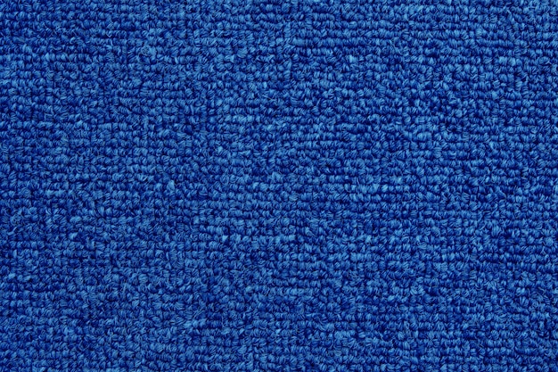 プレミアム写真 シームレスパターンを持つ濃い青のカーペットテクスチャ背景のクローズアップ