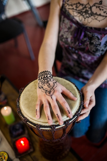 彼女の手に一時的な刺青のタトゥーとボンゴドラムを演奏する女性のクローズアップ 無料の写真