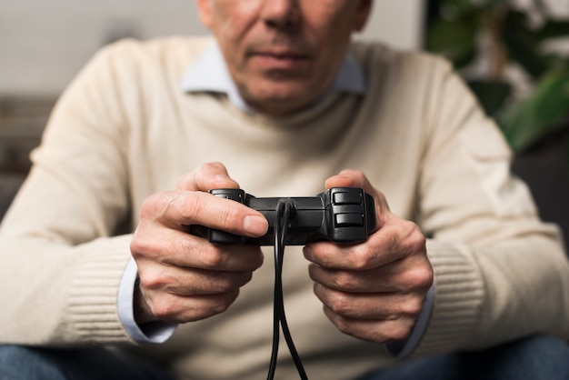 Free Photo Close Up Old Man Holding Controller 3986
