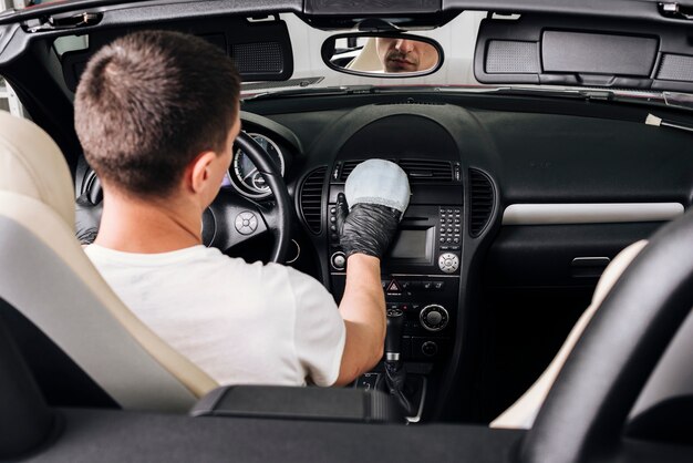Close up of person cleaning car interior Free Photo
