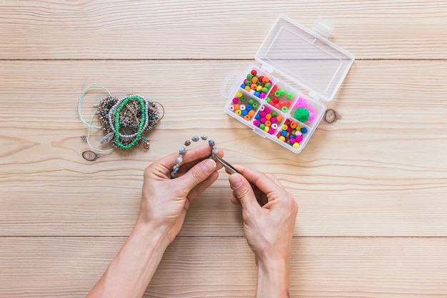 Download Free Close Up Of A Person Making Handmade Bracelet With Tweezers Free Photo Use our free logo maker to create a logo and build your brand. Put your logo on business cards, promotional products, or your website for brand visibility.